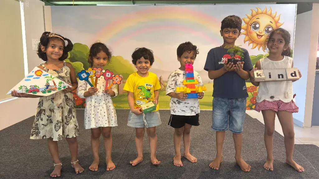 ULTRA_school children proudly showing their projects — artwork, numbers, blocks, a plant and word cards