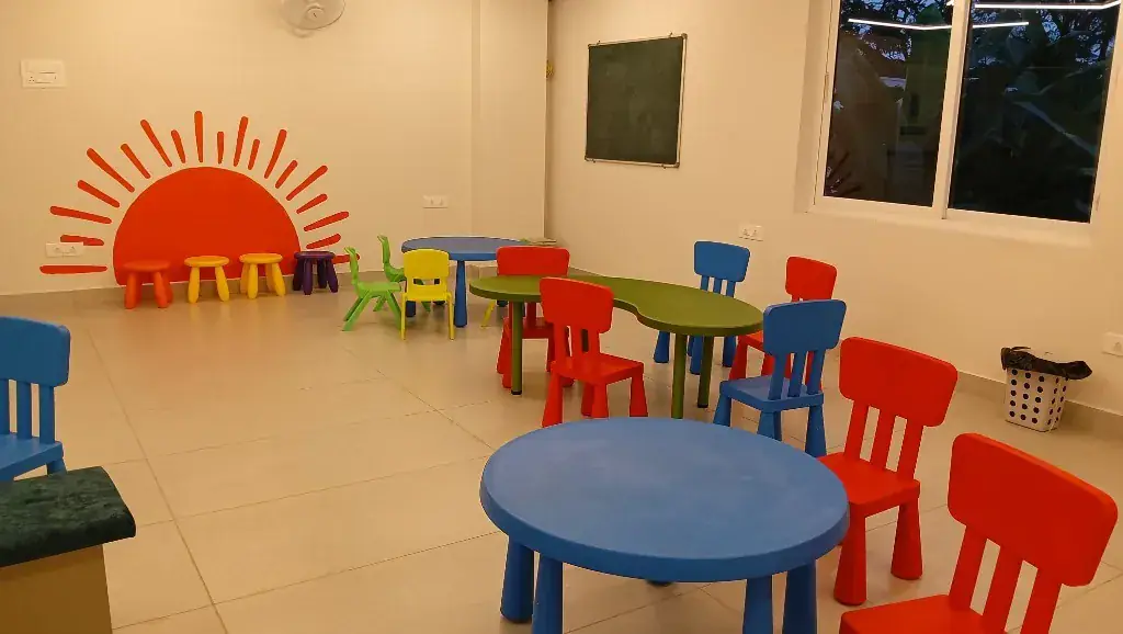 Bright ULTRA_school classroom with colourful child-sized tables, chairs and a sunrise wall