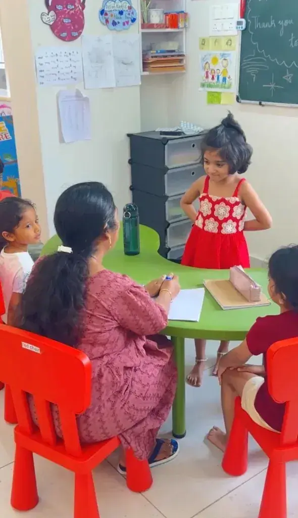 Mentor and children learning together at a small table at ULTRA_school Kochi