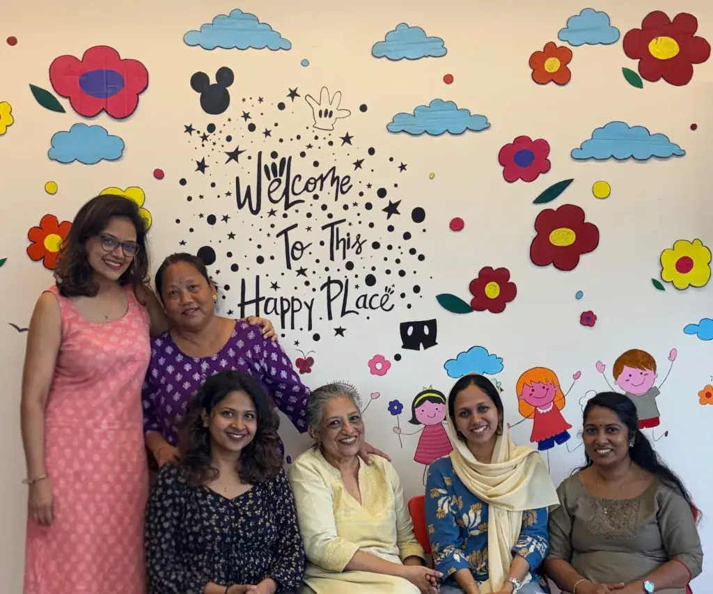 The ULTRA_school teaching and non-teaching team in front of the Happy Place wall